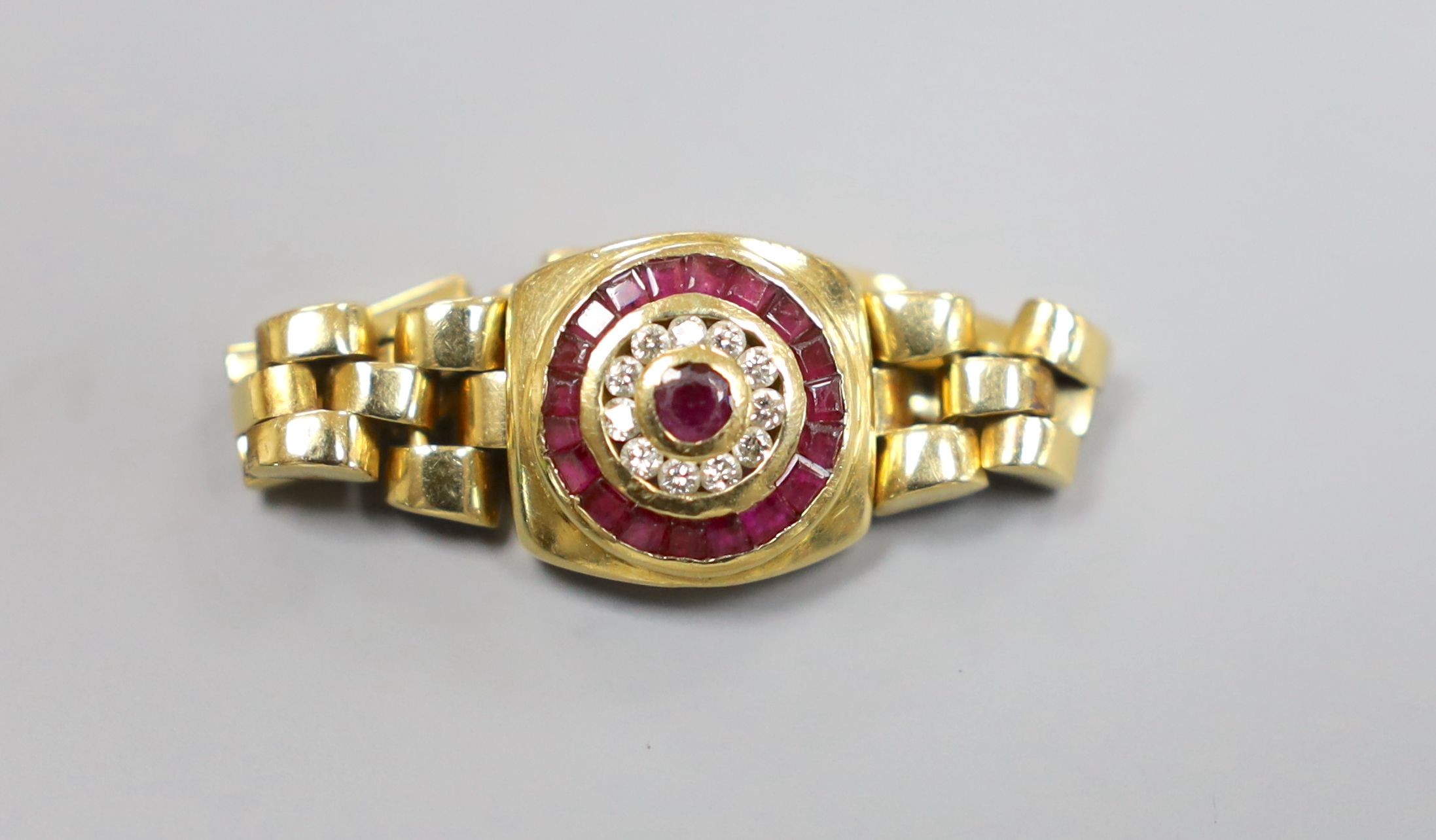 A modern 750, ruby and diamond circular cluster set ring, with articulated shank and clasp, size S. gross weight 8.4 grams.
